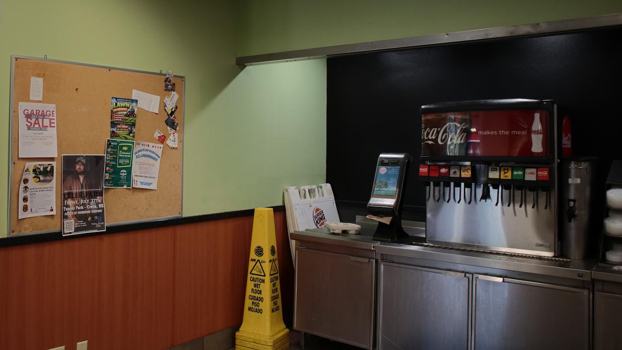 A community board to the left of a Burger King soda machine.