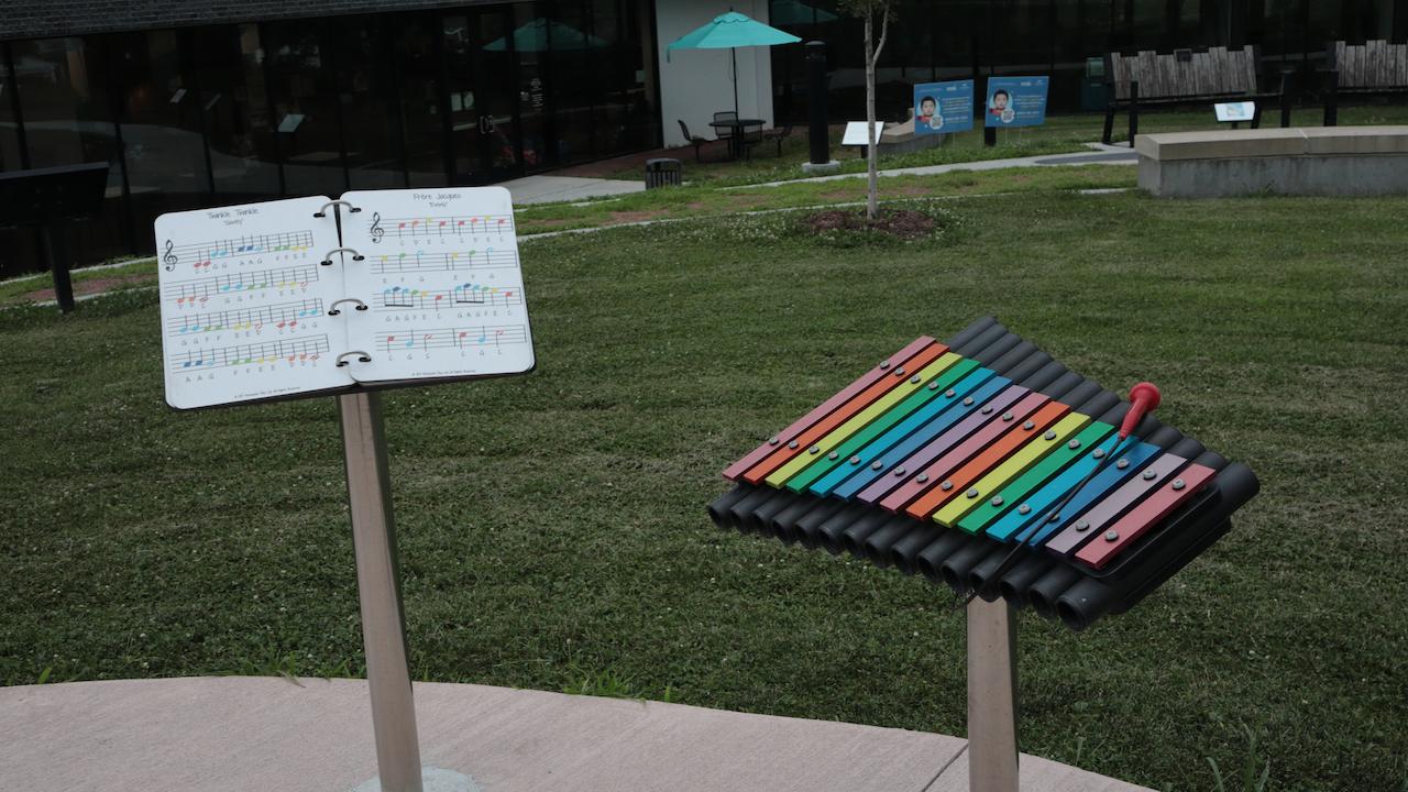 A library xylophone to the right of a booklet of music.