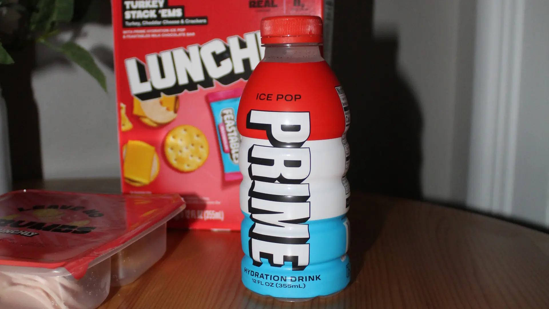 Ice Pop flavored Prime Energy drink in front of a Lunchly box